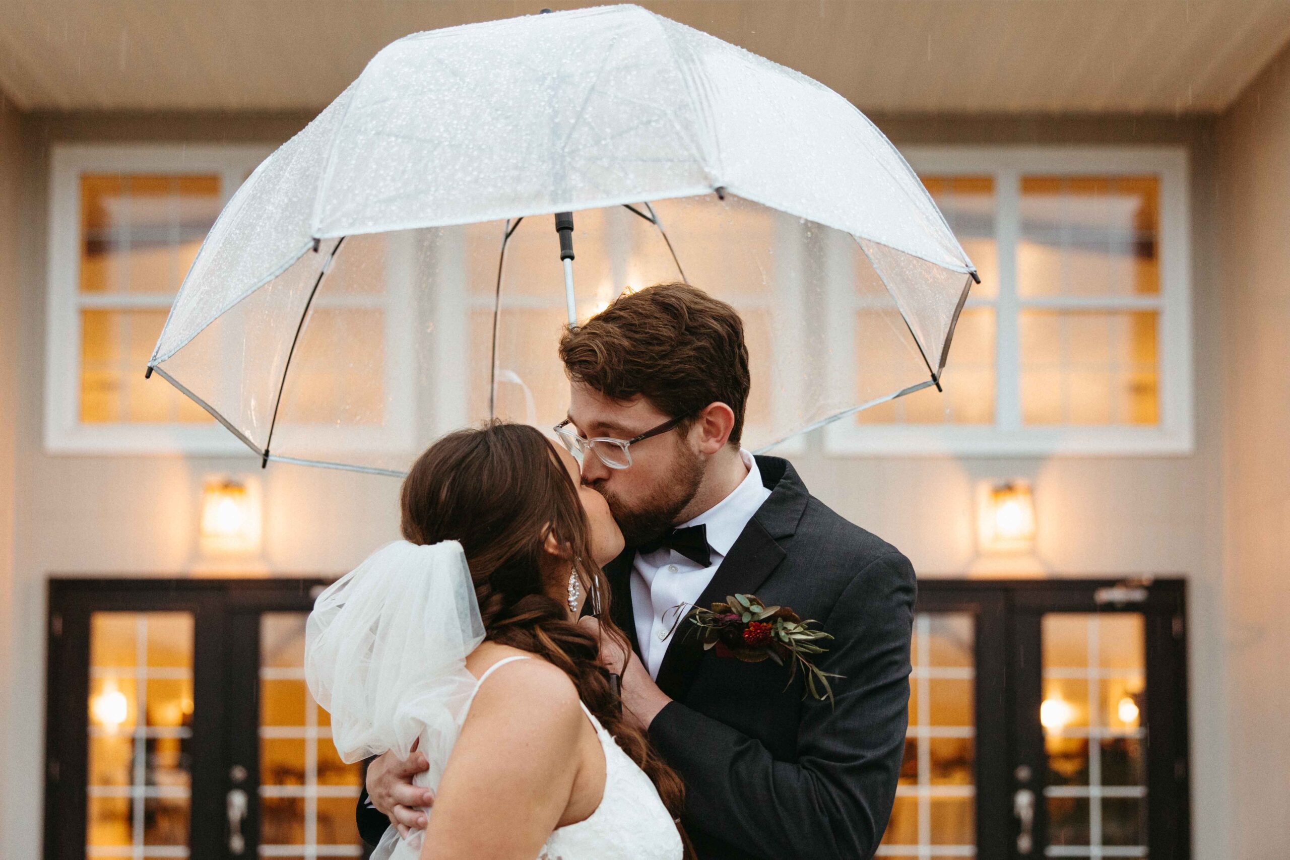 Wedding couple under umbrella on their rainy wedding day